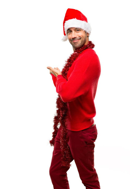 Adam geri işaret ve bir ürün yalıtılmış beyaz arka plan üzerinde sunma Noel tatili kutlama kırmızı elbiseler ile - Fotoğraf, Görsel
