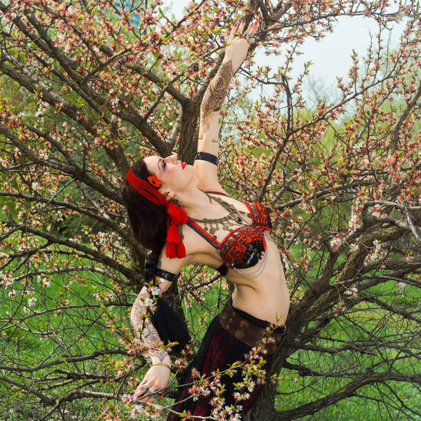 Girl dancing on the background of blossoming spring tree - Foto, afbeelding