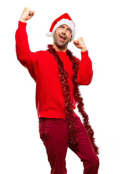 Mann mit roter Kleidung feiert die Weihnachtsfeiertage und feiert einen Sieg auf isoliertem weißem Hintergrund - Foto, Bild