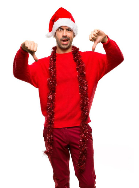 Man with red clothes celebrating the Christmas holidays showing thumb down with both hands on isolated white background - Photo, Image