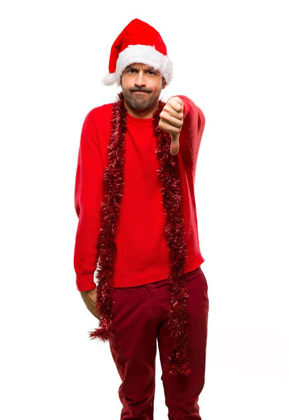 Człowiek z czerwone ubrania z okazji świąt Bożego Narodzenia, Wyświetlono kciuk w dół znak z negatywne wypowiedzi na na białym tle - Zdjęcie, obraz