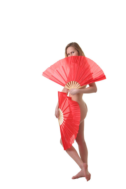 Young attractive naked woman dancing  with two red fans - Foto, afbeelding