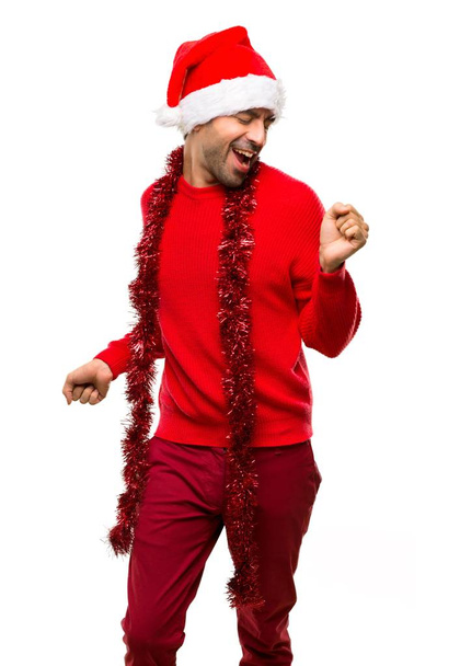 Мужчина в красной одежде, празднующий Рождество, наслаждается танцами, слушая музыку на вечеринке на изолированном белом фоне
 - Фото, изображение