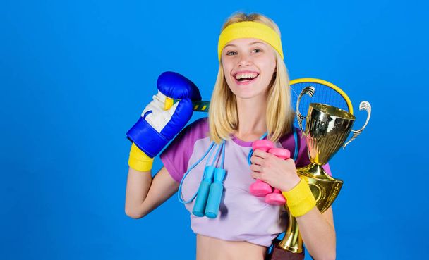 Fitness champion. Champion concept. Girl successful modern woman hold golden goblet of champion. Woman good in tennis jumping boxing fitness sport. How to find time for everything. Sport champion - Fotó, kép