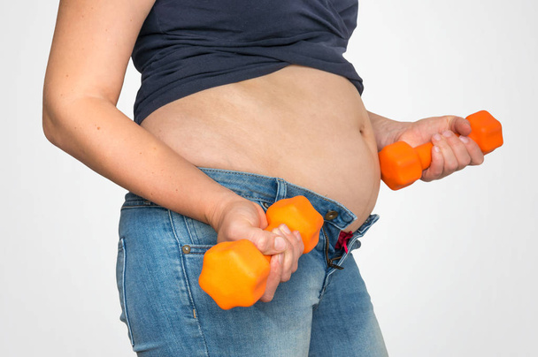 Overweight woman doing sport exercises with dumbbells - overweight and obesity concept - Foto, Imagen