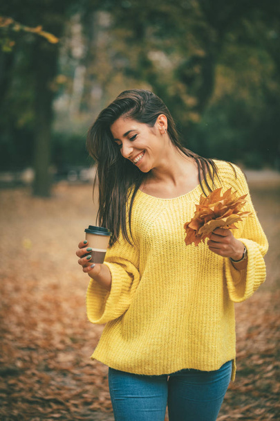 junge Frau spaziert und trinkt Kaffee im Herbstpark - Foto, Bild