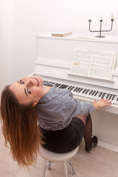 Young attractive girl play piano - 写真・画像