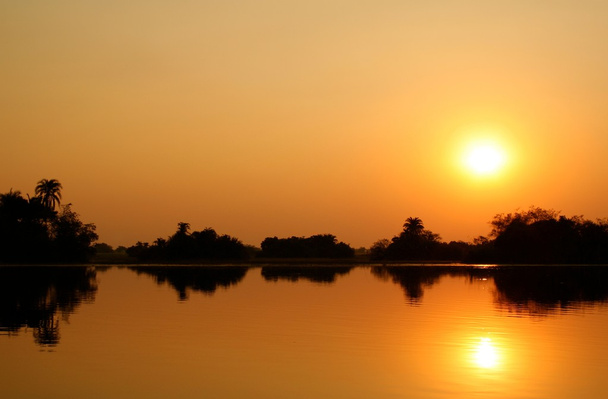 puesta de sol africana en el agua
 - Foto, Imagen