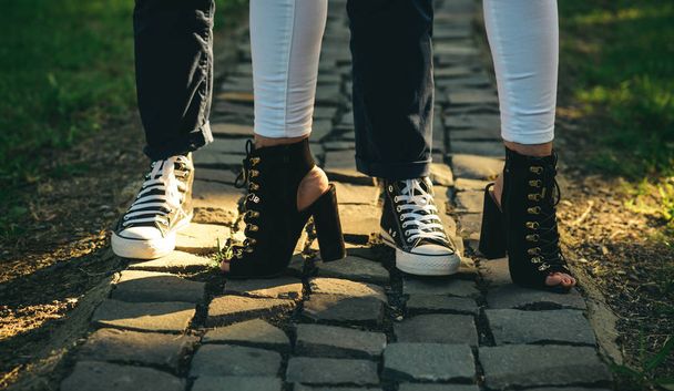 靴を移動するように設計。人間の足は、若者のファッション流行の靴を着用します。現代の靴で女性と男性の足。カジュアルなファッションのトレンド。レディースとメンズの靴。最高のストリート ・ ファッション スタイル - 写真・画像