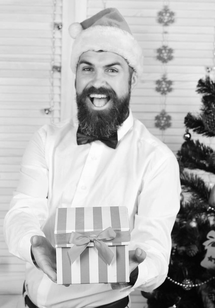 Man with beard and bow tie holds striped present box - Zdjęcie, obraz