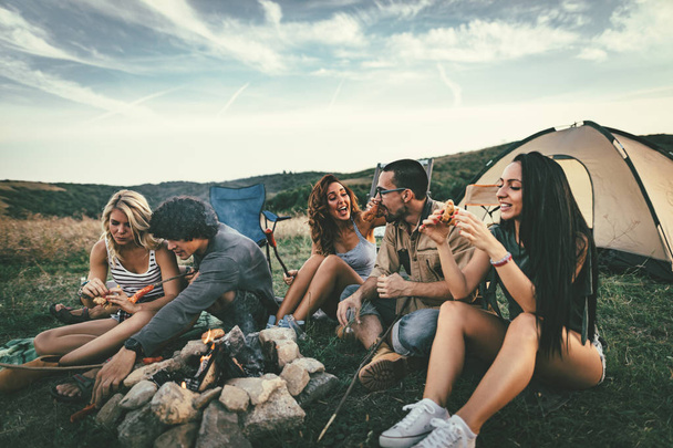 Alegre jóvenes amigos que se divierten en el picnic en el paisaje salvaje
  - Foto, imagen
