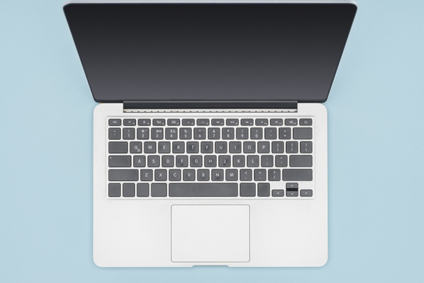 Top view of laptop with blank screen isolated on light blue  - Foto, Bild