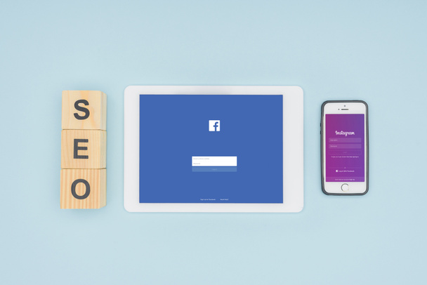 Top view of digital devices with facebook and instagram apps on light blue background  - Photo, Image
