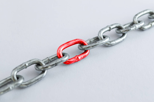 Diagonal metal chain, with red link - Photo, Image