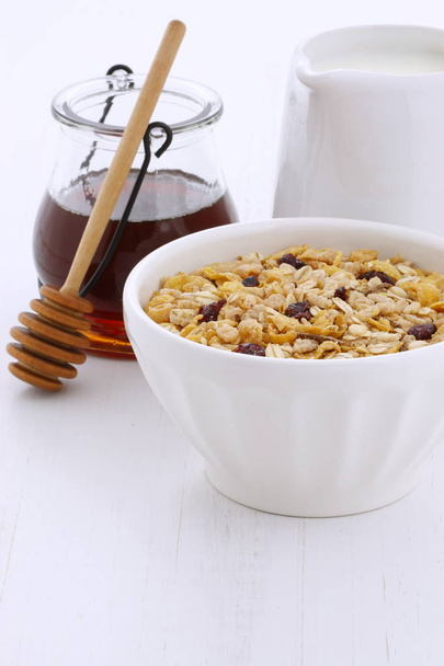 Delicious and nutritious breakfast muesli or granola cereal with milk on vintage styling. - Fotografie, Obrázek