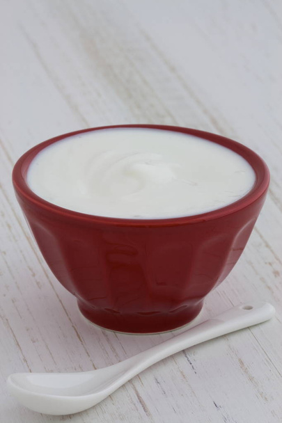Delicious, nutritious and healthy fresh plain greek  yogurt on antique wood table - Fotoğraf, Görsel