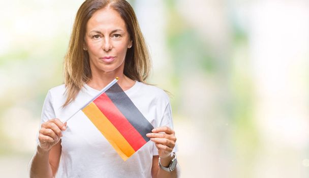 Wieku średniego gospodarstwa banderą Niemiec na na białym tle pewność w ekspresji na twarzy inteligentne myślenia poważne hiszpanin Kobieta - Zdjęcie, obraz