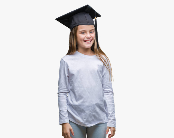Young beautiful girl wearing graduate cap over isolated background with a happy and cool smile on face. Lucky person. - Photo, Image