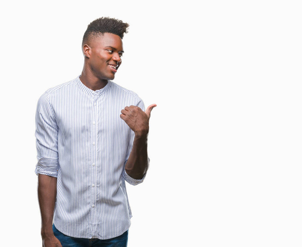 Afro-amerikai fiatalember át elszigetelt háttér, mosolygós, boldog arc, keres, és a hüvelykujj oldalán felfelé mutató. - Fotó, kép