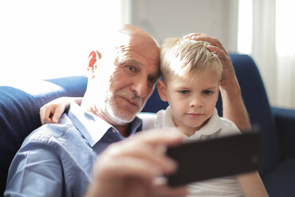 grandfather and grandchild are taking selfies - Foto, Bild