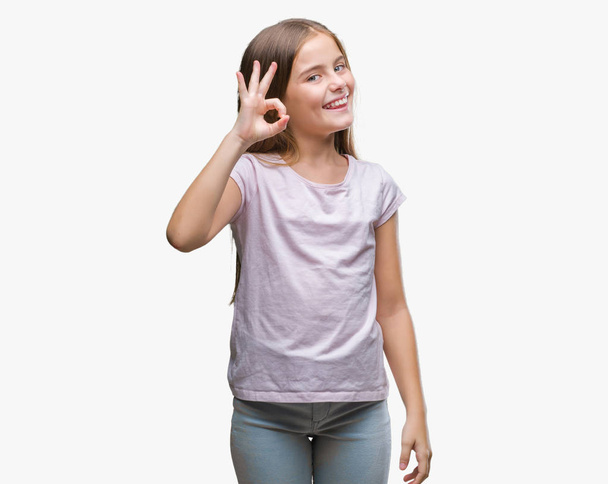 Young beautiful girl over isolated background smiling positive doing ok sign with hand and fingers. Successful expression. - Foto, Imagem