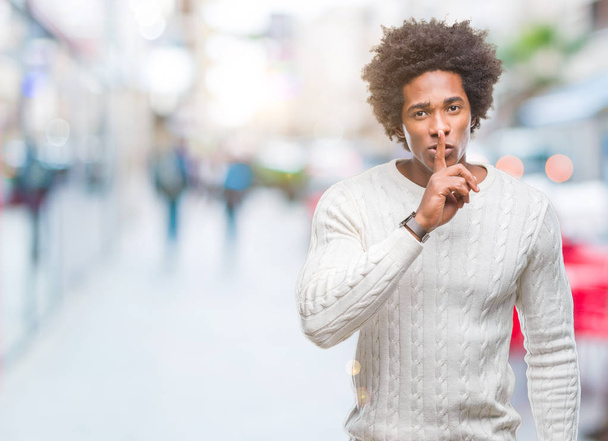 Afro-amerikai ember feletti elszigetelt háttér kérdezés-hoz csendes ujjával a száját. Csend és titkos koncepció. - Fotó, kép