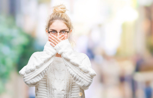 Young beautiful blonde woman wearing glasses over isolated background shocked covering mouth with hands for mistake. Secret concept. - Fotoğraf, Görsel