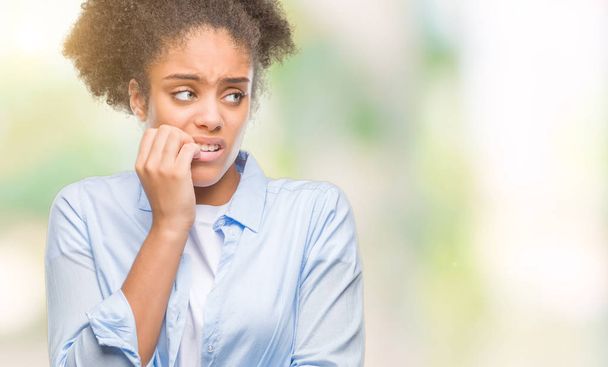Young afro american woman over isolated background looking stressed and nervous with hands on mouth biting nails. Anxiety problem. - Foto, afbeelding