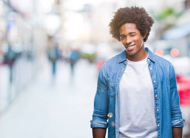 afroamerikanischer Mann vor isoliertem Hintergrund, der mit sexy Gesichtsausdruck, fröhlichem und glücklichem Gesicht in die Kamera blickt. - Foto, Bild