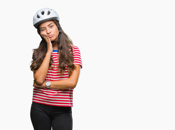 Kobieta młody arab rowerzysta na sobie kask patrząc myślenia na białym tle zmęczony i znudzony depresji problemów ze skrzyżowanymi ramionami. - Zdjęcie, obraz