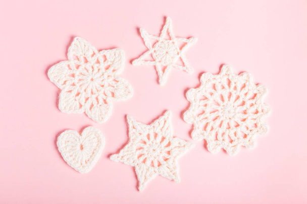 かぎ針編みの白い雪と、ピンクの背景の星のクリスマス組成物。フラット トップ ビュー レイアウト、コピー スペース. - 写真・画像