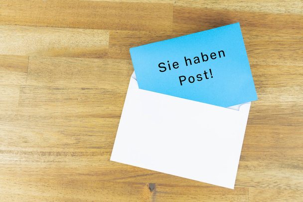 Envelope with a blue note with the german words for you have mail - Photo, Image