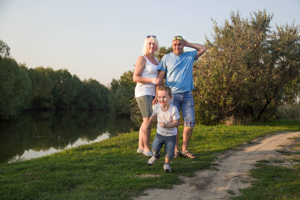 Happy parents having fun and playing with the child in nature. - Zdjęcie, obraz