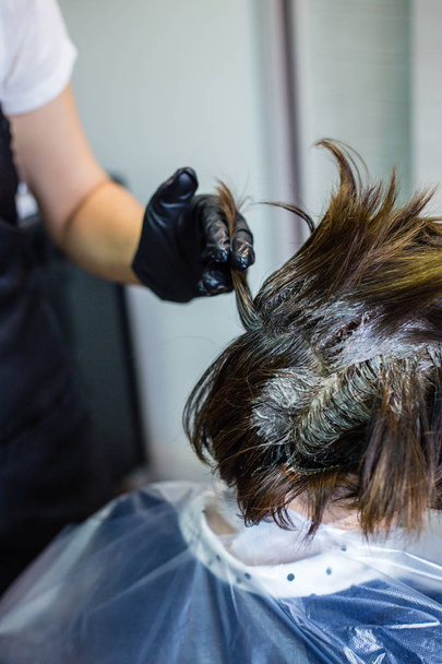 Salón de belleza, peluquería teñir el cabello cliente, agita el tinte
 - Foto, Imagen