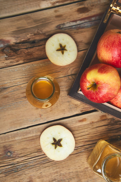 Alma almabor ecet. Bio Almaecet a fából készült asztal üveg. Egészséges szerves ital étel. Üveg friss Alma közelében őszi piros alma. Rusztikus háttér felülnézeti hely szöveg - Fotó, kép