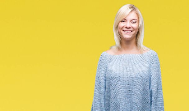 junge schöne blonde Frau trägt Winterpullover über isoliertem Hintergrund mit einem fröhlichen und kühlen Lächeln im Gesicht. Glück gehabt. - Foto, Bild