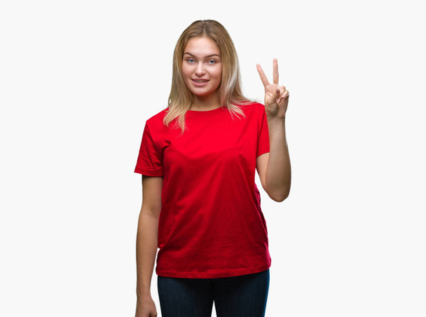 Молодая белая женщина на изолированном фоне показывает и показывает пальцами номер два, улыбаясь уверенно и счастливо
. - Фото, изображение