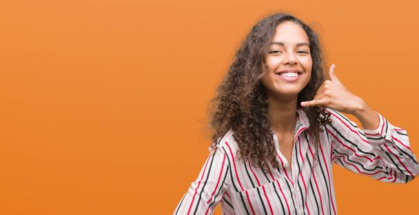 Bella giovane donna ispanica sorridente fare gesto del telefono con le mani e le dita come parlare al telefono. Concetti comunicativi
. - Foto, immagini