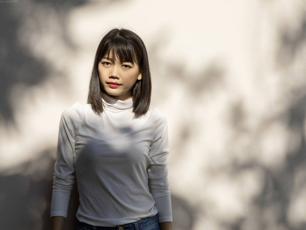 gyönyörű fiatal ázsiai nő fehér falnak állandó portréja - Fotó, kép