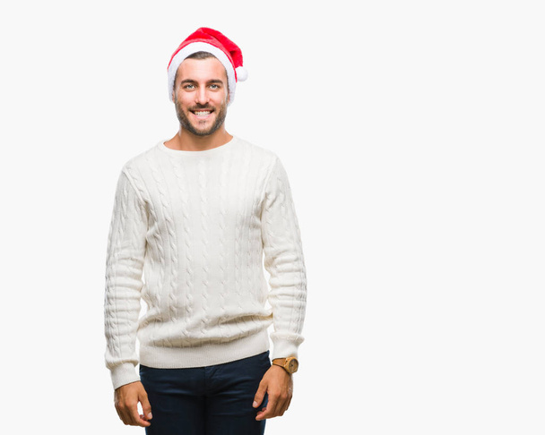 Giovane bell'uomo che indossa il cappello di Babbo Natale su sfondo isolato con un sorriso felice e fresco sul viso. Persona fortunato
. - Foto, immagini