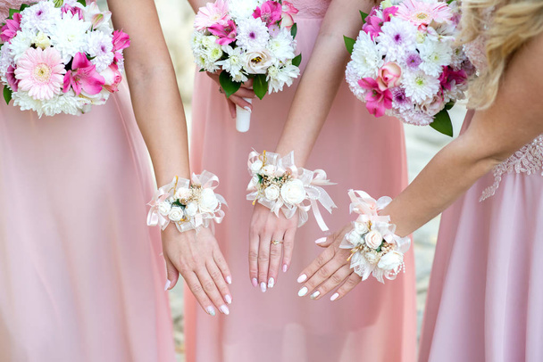 Glorieuze bruidsmeisjes in roze jurken mooie bloemen - selectieve aandacht houden - Foto, afbeelding