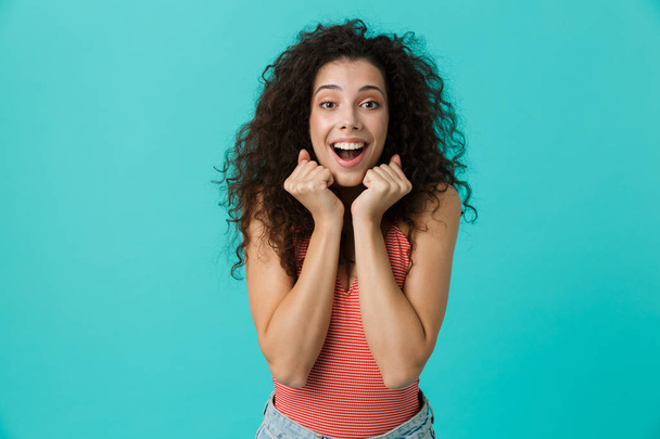 Image of curly woman 20s wearing casual clothing laughing standing isolated over blue background - Photo, Image