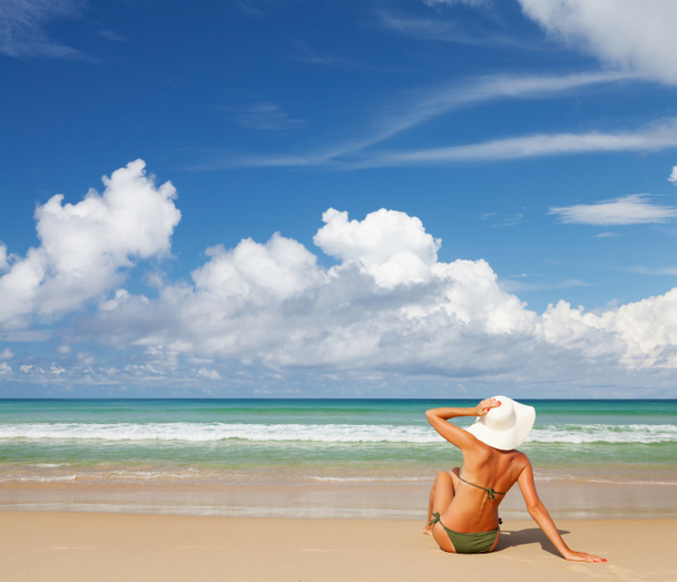 Nuori viehättävä nainen rentoutua meren rannalla. Kirkas hiekka, sininen taivas ja kristallimeri. Trooppinen ranta loma käsite. Kopioi tilaa
 - Valokuva, kuva