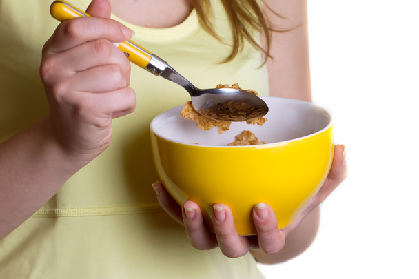 Ruokavalion aamiainen tyttö tilalla kulhoon viljaa
 - Valokuva, kuva