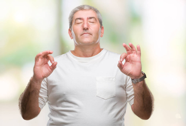 Starší muž izolované pozadí relaxovat a usmívající se očima uzavřené vede meditační gesta prsty. Koncept jógy. - Fotografie, Obrázek