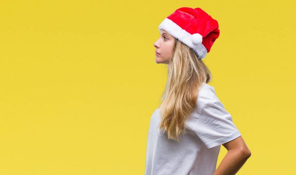 Nuori kaunis blondi nainen yllään joulu hattu yli eristetty tausta etsii sivuun, rentoutua profiili aiheuttaa luonnolliset kasvot luottavainen hymy
. - Valokuva, kuva