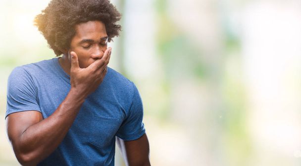 Afro-Amerikaanse man over geïsoleerde achtergrond verveeld geeuwen moe die betrekking hebben op mond met de hand. Restless en slaperigheid. - Foto, afbeelding