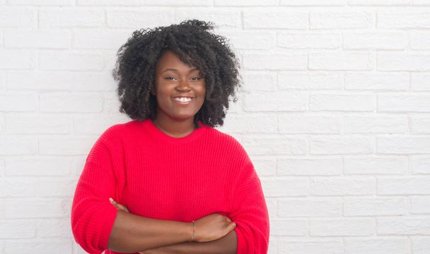 Young african american plus size woman over white brick wall happy face smiling with crossed arms looking at the camera. Positive person. - Foto, imagen