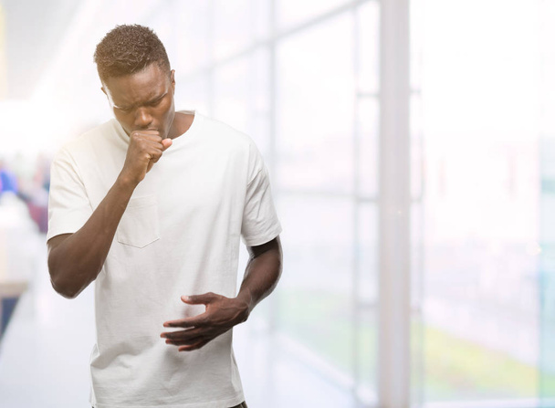 Afro-amerikai fiatalember visel fehér póló, közérzet és köhögés, mint tünet a hideg vagy a hörghurut. Egészségügyi koncepció. - Fotó, kép