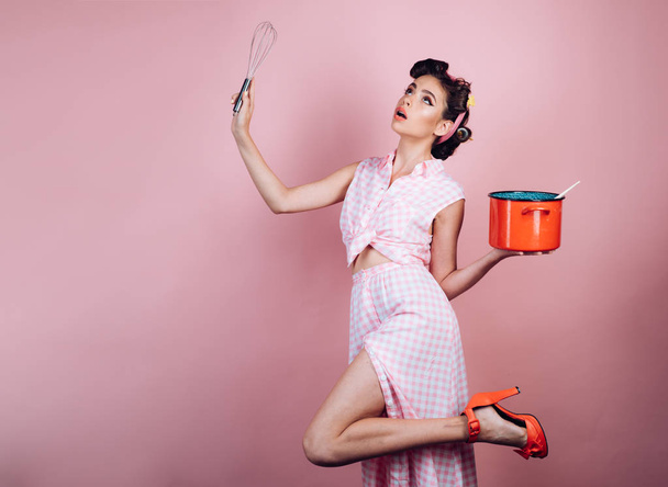 pretty girl in vintage style. retro woman cooking in kitchen. pin up woman with trendy makeup. pinup girl with fashion hair. perfect housewife. Cooking by recipe - Fotoğraf, Görsel
